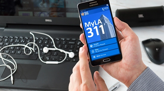 Person holding a mobile phone with the MyLA311 App 